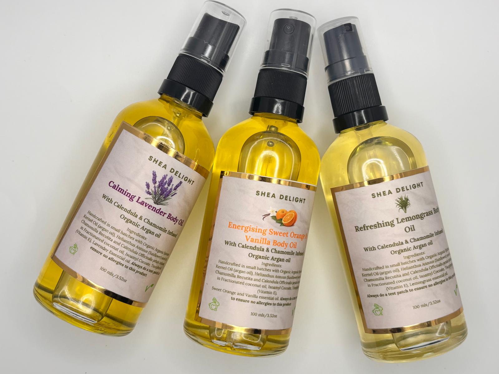 Three bottles of Shea Delight body oils with labels on a white background